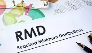 RMD Required Minimum Distributions document beside charts, glasses, and pens